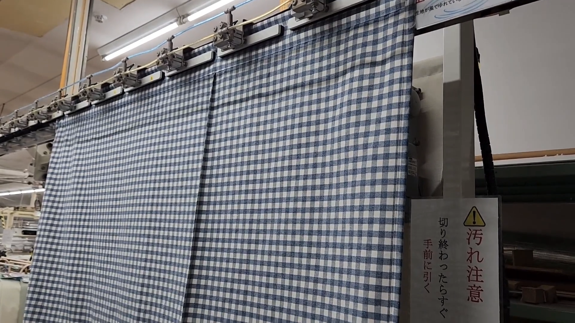 丈決め設備に生地をセットする様子